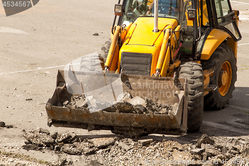 Image of Tractor Dismantles Asphalt