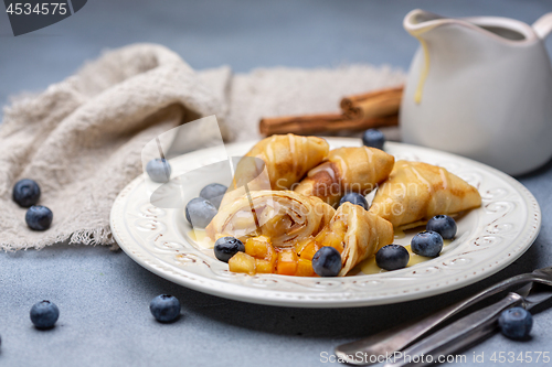 Image of Crepes with apple filling, blueberry and caramel sauce.