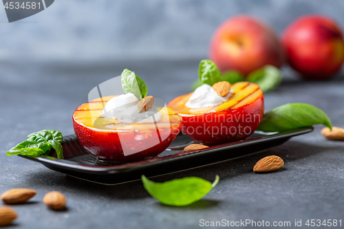 Image of Grilled peach with honey, yogurt and almonds.