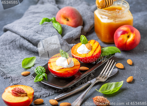 Image of Grilled peaches with yogurt,honey and green basil.