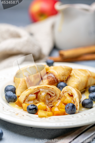 Image of Homemade crepes with apples and caramel sauce.