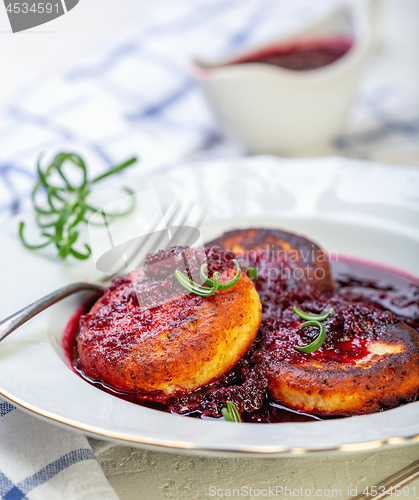 Image of Curd fritters with cherry sauce and rosemary.