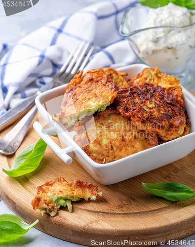 Image of Zucchini fritters with sour cream sauce.