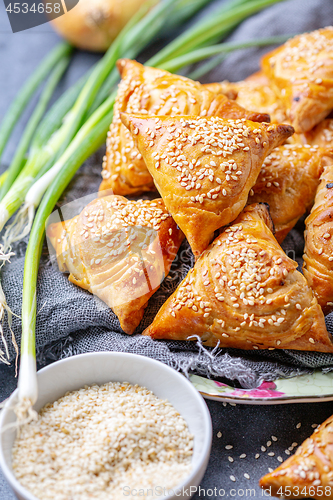 Image of Homemade samosas sprinkled with sesame seeds.