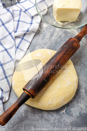 Image of Dough is rolled out with rolling pin for the dough