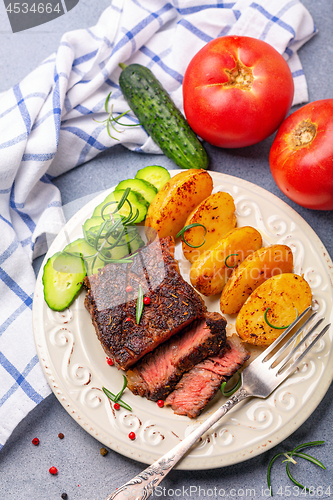 Image of Steak with pink pepper, rosemary and baked potatoes.