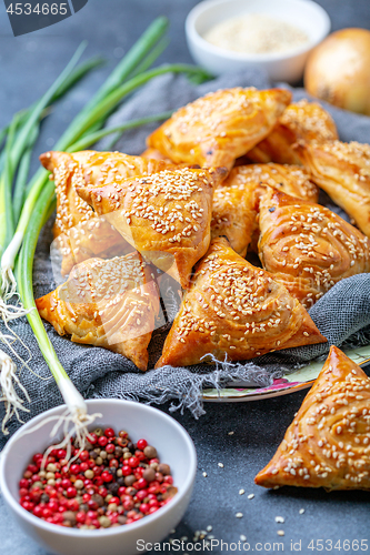 Image of Samosas with meat sprinkle with sesame seeds.