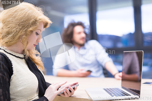 Image of Elegant Woman Using Mobile Phone in startup office building