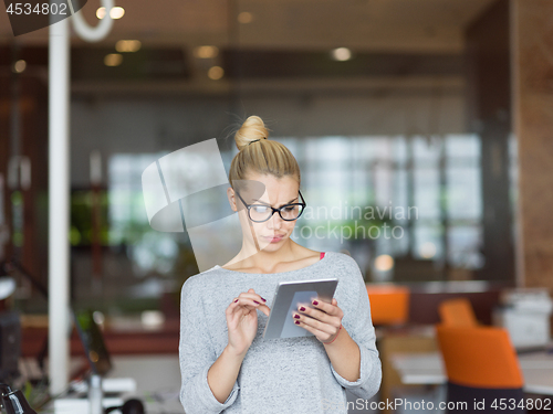 Image of woman working on digital tablet in night office