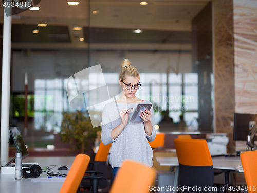 Image of woman working on digital tablet in night office