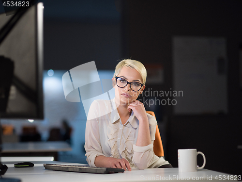 Image of woman working on computer in dark office