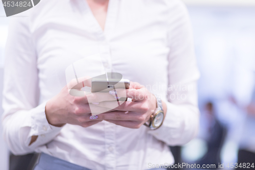 Image of Elegant Woman Using Mobile Phone in startup office building