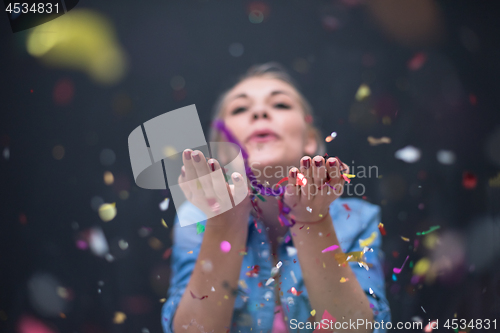 Image of woman blowing confetti in the air