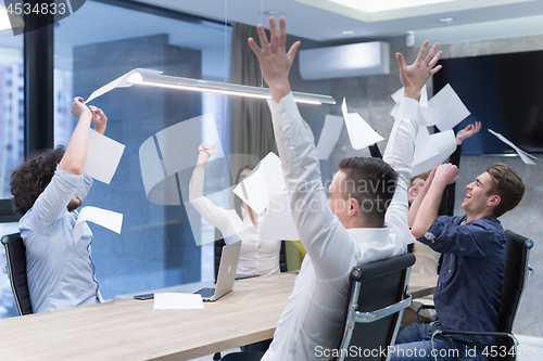 Image of startup Group of young business people throwing documents