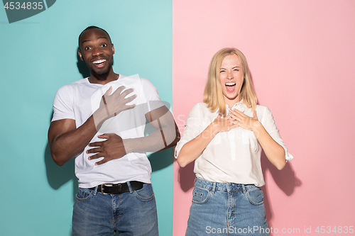 Image of happy afro man and woman. Dynamic image of caucasian female and afro male model on pink studio.