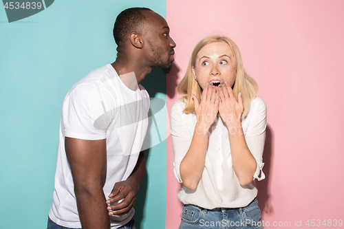 Image of happy afro man and woman. Dynamic image of caucasian female and afro male model on pink studio.