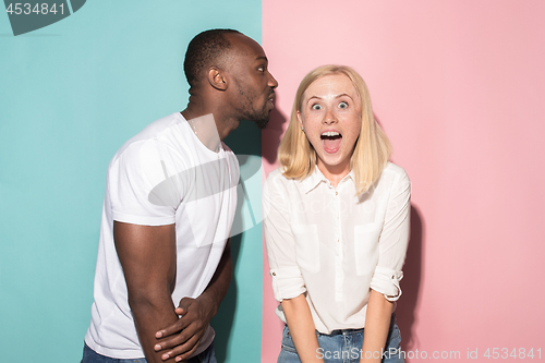 Image of happy afro man and woman. Dynamic image of caucasian female and afro male model on pink studio.