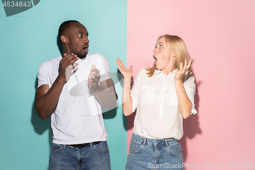 Image of Beautiful woman and afro woman looking suprised isolated on pink