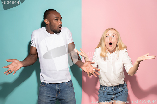 Image of Beautiful woman and afro woman looking suprised isolated on pink