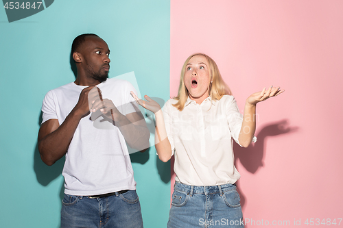 Image of Beautiful woman and afro woman looking suprised isolated on pink