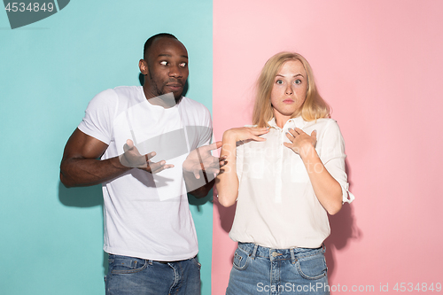 Image of Beautiful woman and afro woman looking suprised isolated on pink