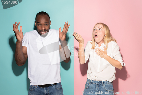 Image of Beautiful woman and afro woman looking suprised isolated on pink