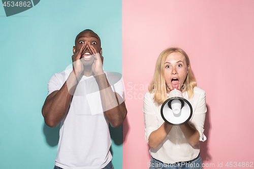 Image of The young emotional angry woman screaming on pink studio background