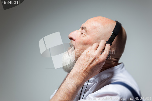 Image of elderly bald head man with headphones