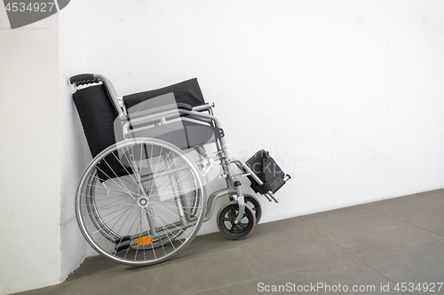 Image of folded wheelchair at a white wall