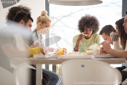 Image of multiethnic group of happy friends lunch time