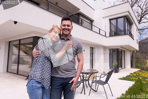 Image of couple hugging in front of  new luxury home