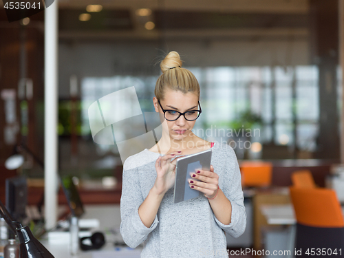 Image of woman working on digital tablet in night office