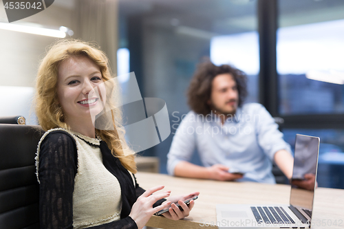 Image of Elegant Woman Using Mobile Phone in startup office building