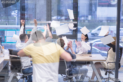 Image of startup Group of young business people throwing documents