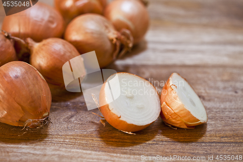 Image of Organic fresh  onions heap closeup on rustic wooden table backgr