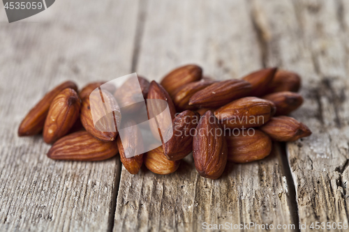 Image of Pile of fresh organic almond seeds on rustick wooden table.