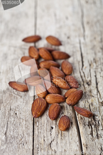 Image of Pile of fresh organic almond seeds on rustick wooden table.