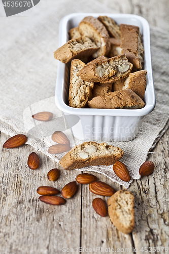 Image of Cookies cantuccini in white ceramic bowl and almond seeds on lin