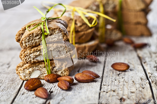 Image of Fresh Italian cookies cantuccini stackes and almond seeds on ruc