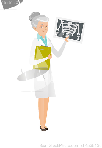 Image of Senior caucasian doctor examining a radiograph.