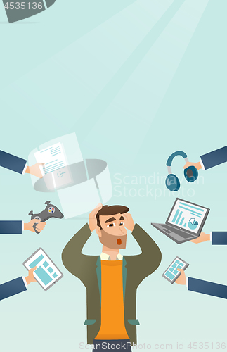 Image of Young caucasian man surrounded by his gadgets.