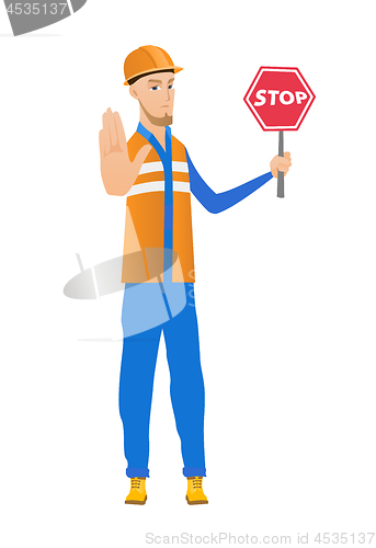 Image of Young caucasian builder holding stop road sign.