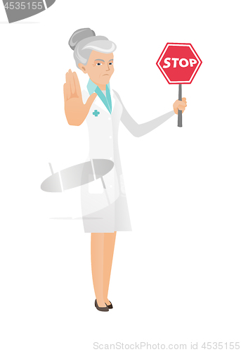 Image of Senior caucasian doctor holding stop road sign.