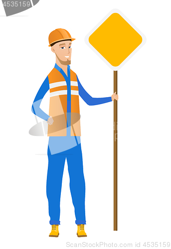 Image of Young caucasian road worker showing road sign.