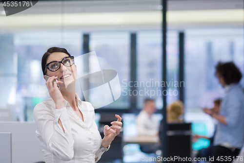 Image of Elegant Woman Using Mobile Phone in startup office building