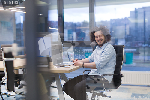 Image of Young casual businessman using smartphone