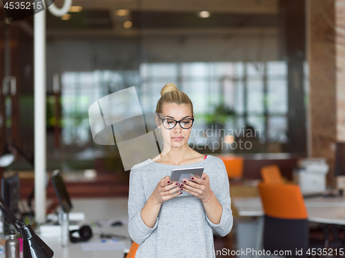 Image of woman working on digital tablet in night office