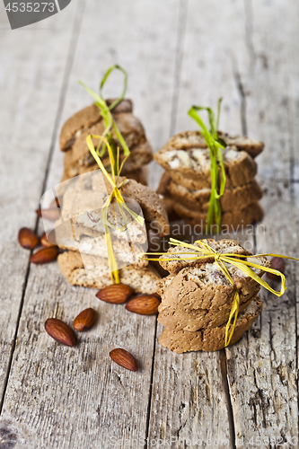 Image of Fresh Italian cookies cantuccini stackes and almond seeds on ruc