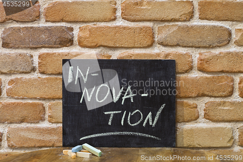 Image of Chalk board with the word INNOVATION drown by hand and chalks on