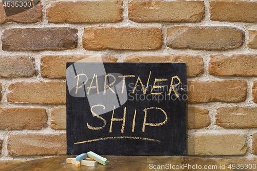 Image of Chalk board with the word PARTNERSHIP drown by hand and chalks o